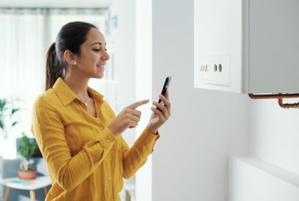 A woman contacts support on her phone for her boiler