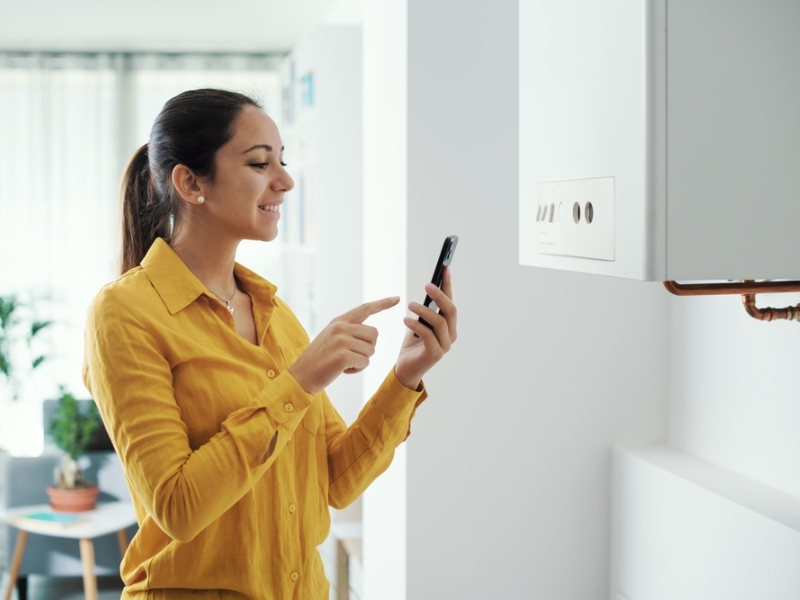 A woman contacts support on her phone for her boiler