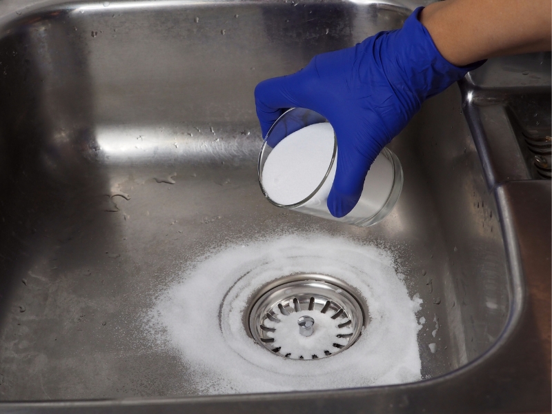 Someone uses baking soda to unclog a sink