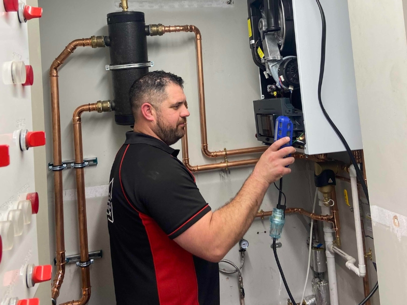 An ECS plumber servicing a boiler