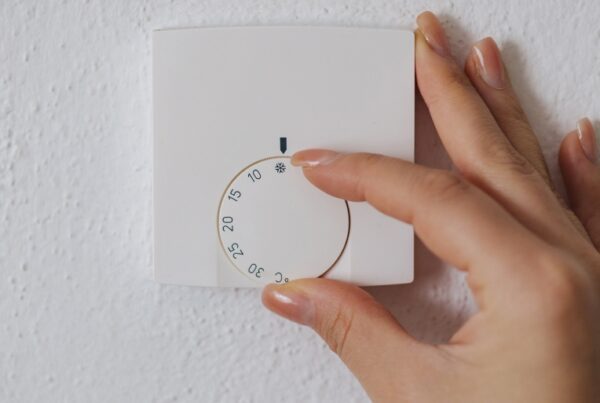 A hand operating a thermostat