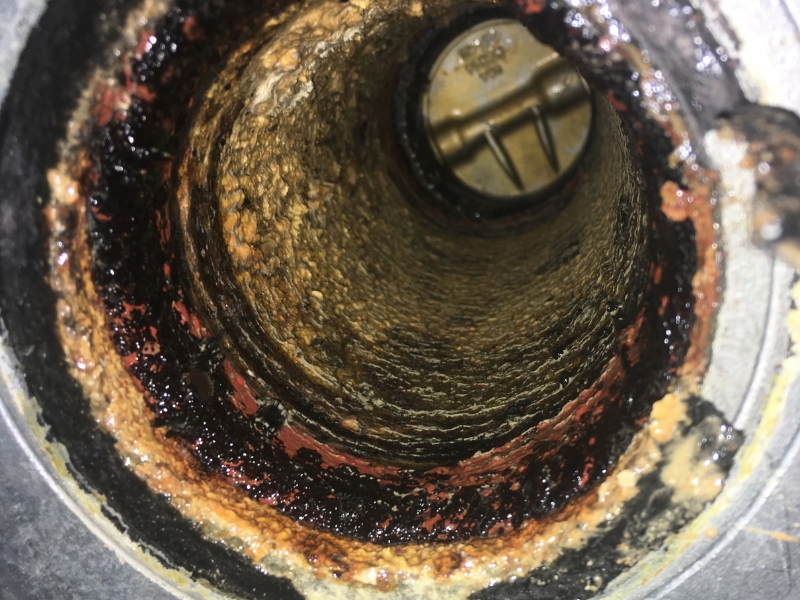 A rusted, clogged pipe in need of plumbing maintenance