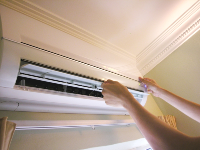 hands conducting maintenance on an air con unit